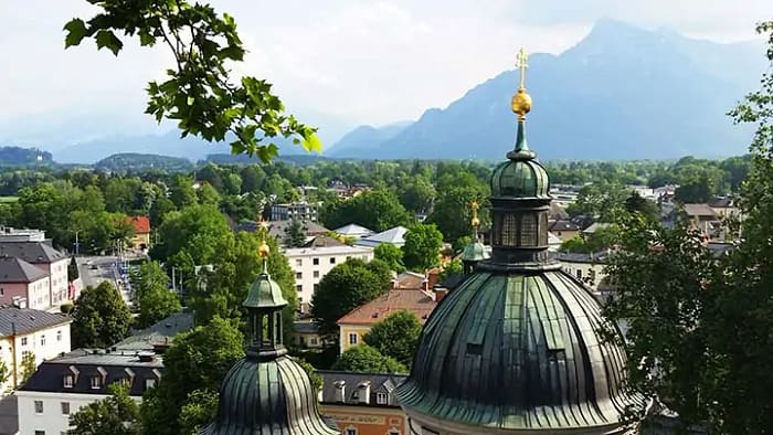 image of a rooftops and green church domes with a mountain in the background. You can tell tourist vs traveler by how they capture the moment.