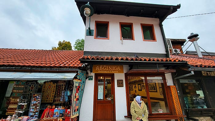 05_Hadzibaric restaurant in sarajevo image of the outside of a cafeteria style restaurant with an old woman sitting in the window