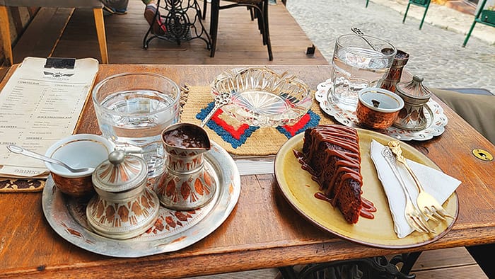 image of a table with Bosnian coffee setups and cake. Slowing down to enjoy these moments is one of the best things to do in Sarajevo.