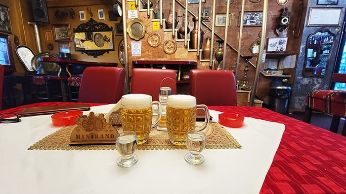 Picture of two glasses of rakije and beer in a traditional Balkan food restaurant