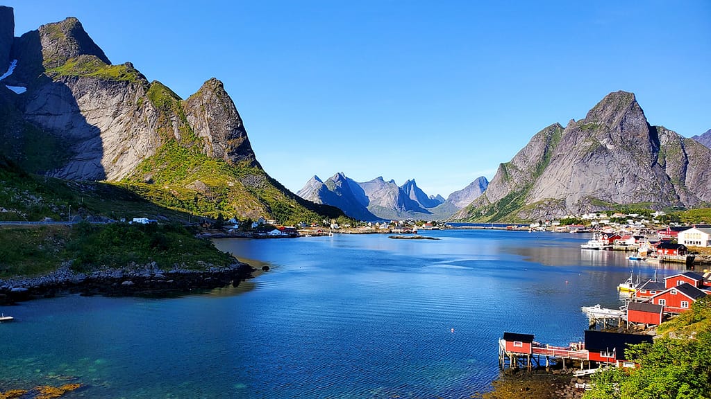 image of the village of Reine in Norway with mountains in the background. One of the places worth planning a European road trip for.