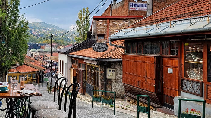 view of cafe tables and the city of Sarajevo in the background